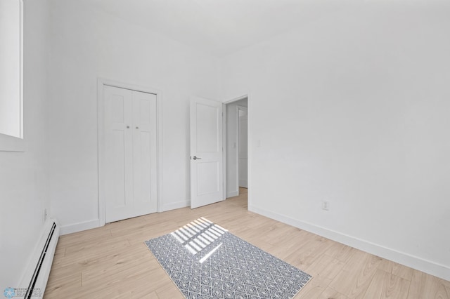 3017 8th St N, Fargo, ND 58102 - unfurnished bedroom with baseboard heating, wood finished floors, and baseboards
