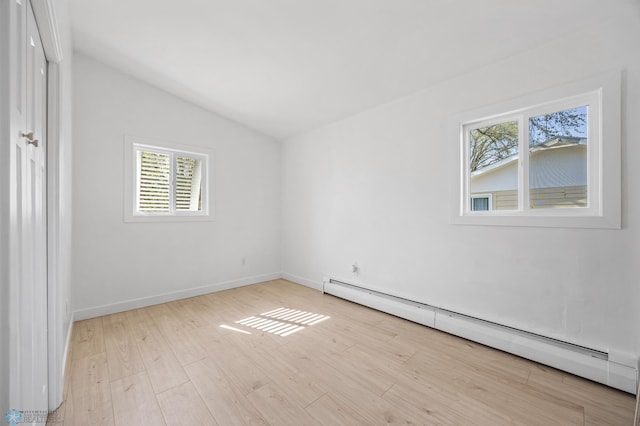 3017 8th St N, Fargo, ND 58102 - unfurnished bedroom with baseboard heating, vaulted ceiling, wood finished floors, and baseboards