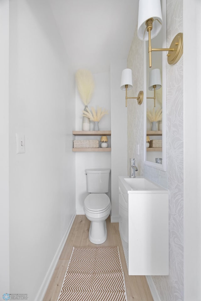 3017 8th St N, Fargo, ND 58102 - bathroom with wood finished floors, toilet, baseboards, and vanity