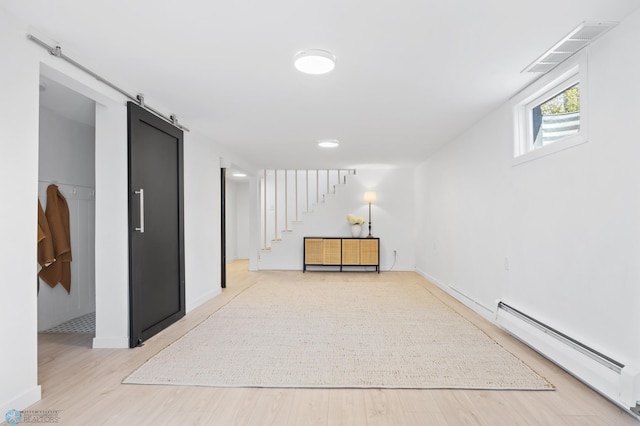 3017 8th St N, Fargo, ND 58102 - empty room with a baseboard radiator, a barn door, stairs, light wood-style floors, and baseboards