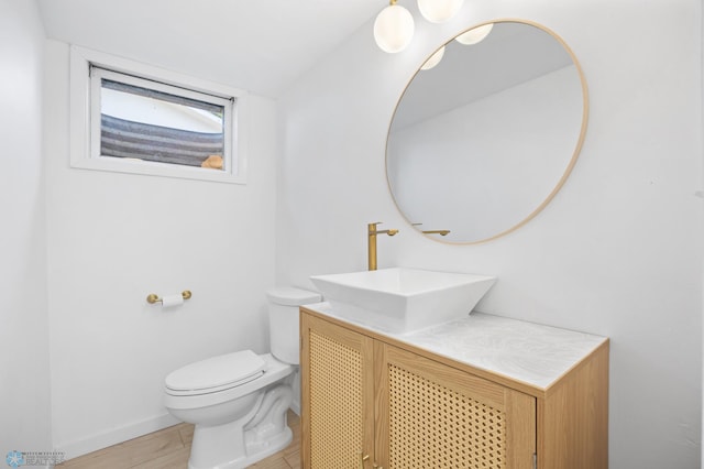 3017 8th St N, Fargo, ND 58102 - half bathroom featuring vanity, toilet, baseboards, and wood finished floors