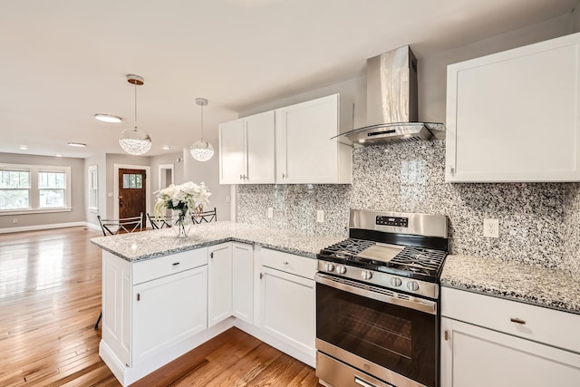 4245 11th Ave S, Minneapolis, MN 55407 - kitchen with wall chimney range hood, gas stove, a peninsula, white cabinetry, and light wood-type flooring