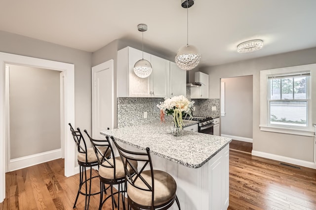 4245 11th Ave S, Minneapolis, MN 55407 - kitchen featuring stainless steel range with gas cooktop, baseboards, and wood finished floors