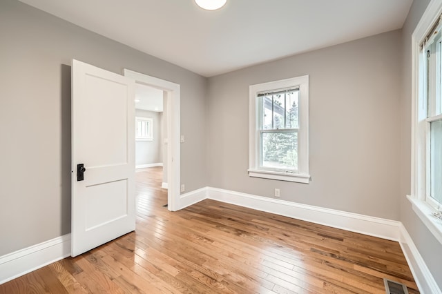 4245 11th Ave S, Minneapolis, MN 55407 - empty room featuring light wood finished floors, plenty of natural light, and baseboards