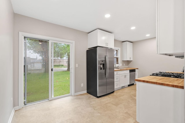 719 9th St E, Glencoe, MN 55336 - kitchen with appliances with stainless steel finishes, wooden counters, a sink, white cabinetry, and baseboards