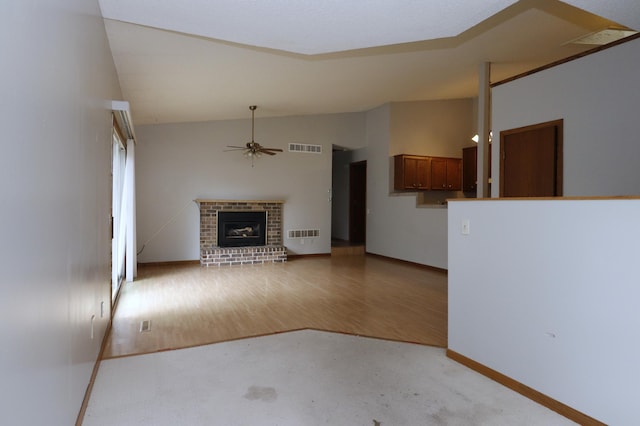 16477 Five Hawks Ave SE, Prior Lake, MN 55372 - unfurnished living room with vaulted ceiling, a ceiling fan, a brick fireplace, baseboards, and light wood-type flooring
