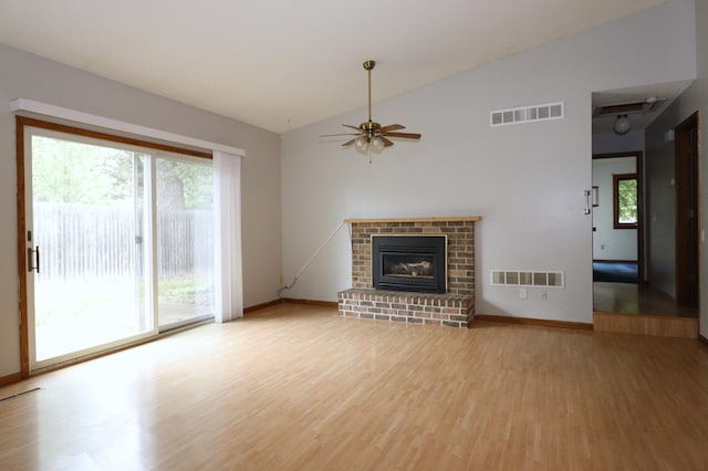 16477 Five Hawks Ave SE, Prior Lake, MN 55372 - unfurnished living room featuring light wood-style floors, lofted ceiling, a ceiling fan, baseboards, and a brick fireplace
