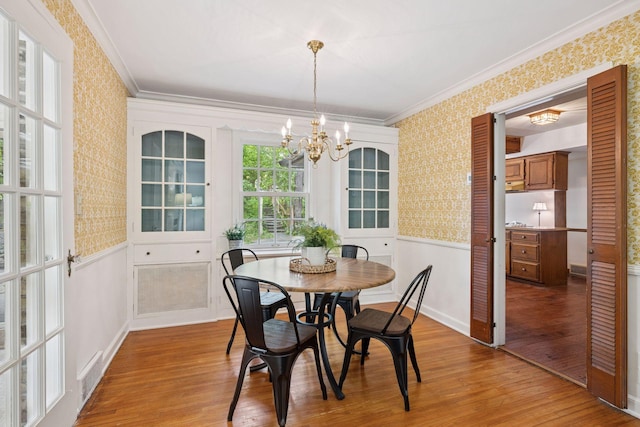 4378 Browndale Ave, Edina, MN 55424 - dining area with wallpapered walls, wood finished floors, a chandelier, crown molding, and a wainscoted wall