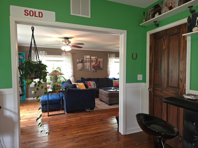 19334 105th Ave, Hayland Twp, MN 56353 - living room featuring wood finished floors, wainscoting, crown molding, and a ceiling fan