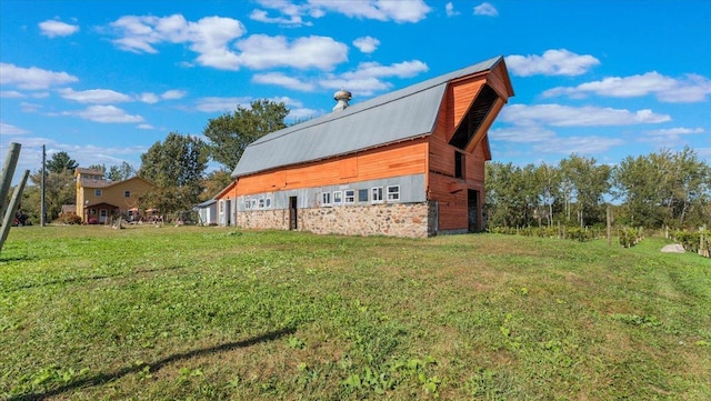 19334 105th Ave, Hayland Twp, MN 56353 - view of side of home featuring a barn, a yard, stone siding, and an outbuilding