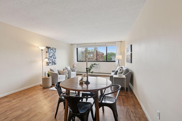 1912 Dupont Ave S Unit 302, Minneapolis, MN 55403 - dining space featuring a textured ceiling, wood finished floors, baseboards, and a baseboard radiator