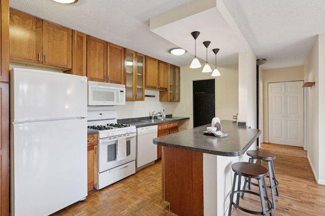 1912 Dupont Ave S Unit 302, Minneapolis, MN 55403 - kitchen featuring white appliances, a sink, dark countertops, and brown cabinetry