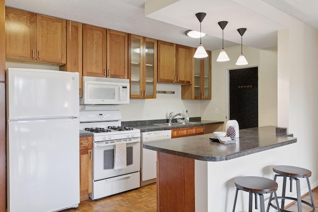 1912 Dupont Ave S Unit 302, Minneapolis, MN 55403 - kitchen with white appliances, a sink, dark countertops, brown cabinetry, and a peninsula