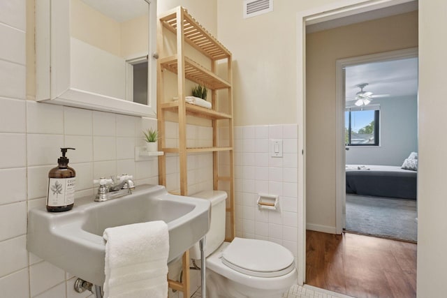 1912 Dupont Ave S Unit 302, Minneapolis, MN 55403 - bathroom featuring tile walls, toilet, wood finished floors, a sink, and ceiling fan