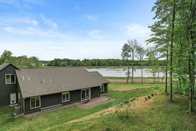 7410 313th Ave NE, North Branch Twp, MN 55056 - back of house featuring a water view, central AC unit, roof with shingles, a patio, and a yard