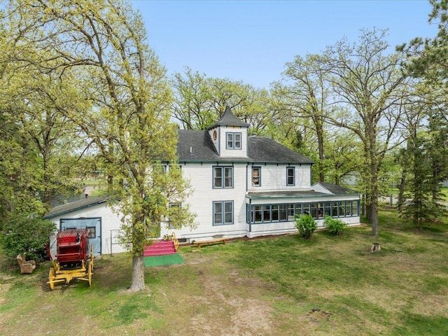 114 Washburn Ave W, Backus, MN 56435 - rear view of house with a sunroom, a lawn, a garage, and roof with shingles