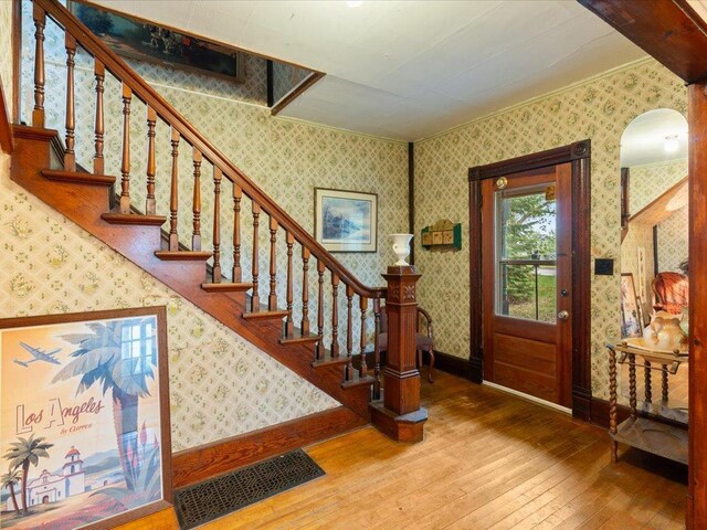 114 Washburn Ave W, Backus, MN 56435 - foyer featuring wallpapered walls, hardwood / wood-style flooring, ornamental molding, baseboards, and stairway