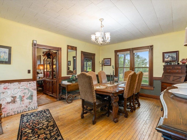 114 Washburn Ave W, Backus, MN 56435 - dining room featuring light wood-style floors, a chandelier, and a wainscoted wall