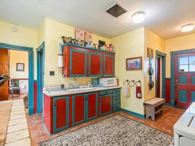114 Washburn Ave W, Backus, MN 56435 - kitchen with white microwave, a sink, light countertops, and baseboards