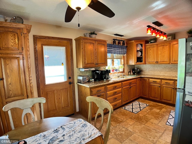 204 10th St N, Sartell, MN 56377 - kitchen with brown cabinetry, freestanding refrigerator, backsplash, and a ceiling fan