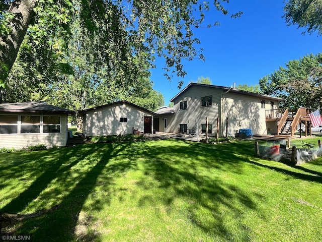 204 10th St N, Sartell, MN 56377 - back of property with a yard, stairs, and a deck