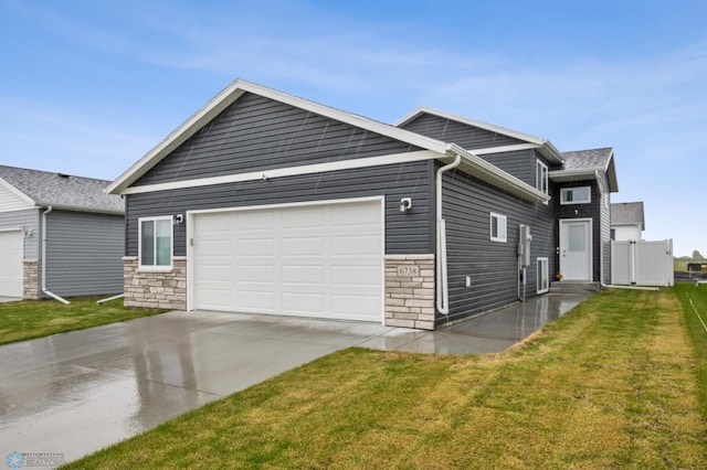 6738 Joseph St, Horace, ND 58047 - view of front of house featuring concrete driveway, stone siding, an attached garage, and a front yard