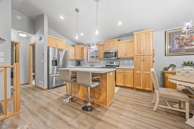 6738 Joseph St, Horace, ND 58047 - kitchen featuring stainless steel appliances, vaulted ceiling, light countertops, a sink, and light brown cabinetry