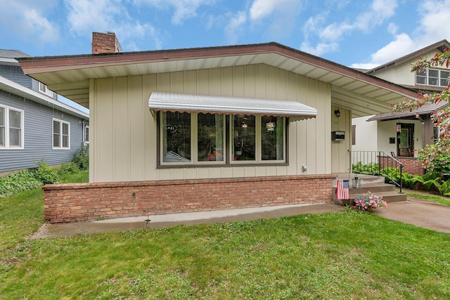 148 21st Ave N, Saint Cloud, MN 56303 - view of front of property featuring a chimney, brick siding, and a front yard