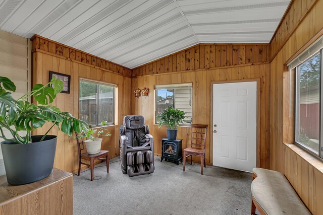 148 21st Ave N, Saint Cloud, MN 56303 - sitting room featuring a wood stove, lofted ceiling, wood walls, and carpet floors