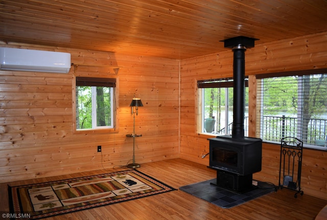 48080 218th Pl, Mcgregor, MN 55760 - interior space with a wall mounted AC, a wood stove, wood finished floors, wooden walls, and wooden ceiling