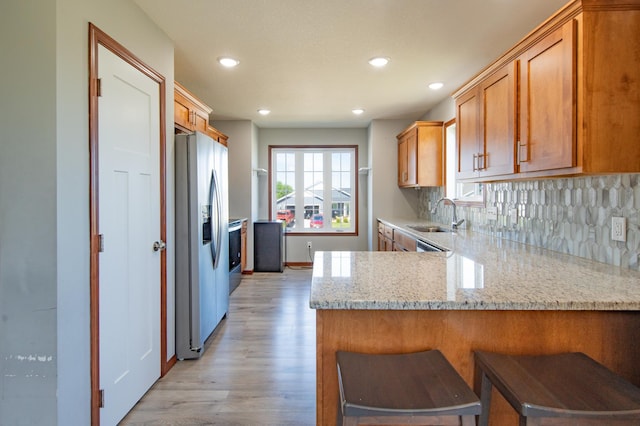 1004 7th Ave NW, Kasson, MN 55944 - kitchen featuring stainless steel refrigerator with ice dispenser, light wood-type flooring, a peninsula, recessed lighting, and tasteful backsplash
