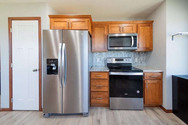 1004 7th Ave NW, Kasson, MN 55944 - kitchen with appliances with stainless steel finishes, light wood-type flooring, and brown cabinetry