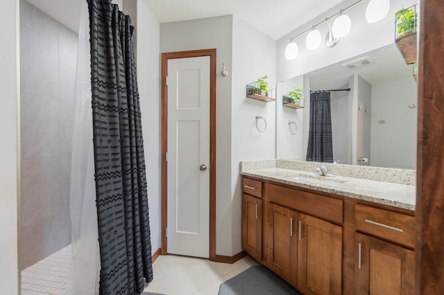1004 7th Ave NW, Kasson, MN 55944 - bathroom with vanity, tiled shower, tile patterned floors, and baseboards