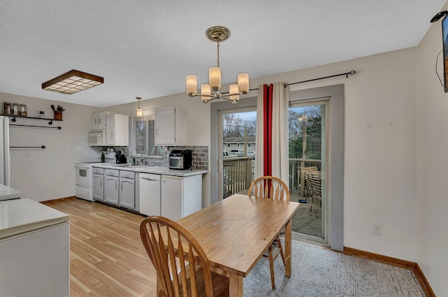 1410 12th Ave N, Saint Cloud, MN 56303 - dining space featuring a chandelier, light wood-style flooring, and baseboards