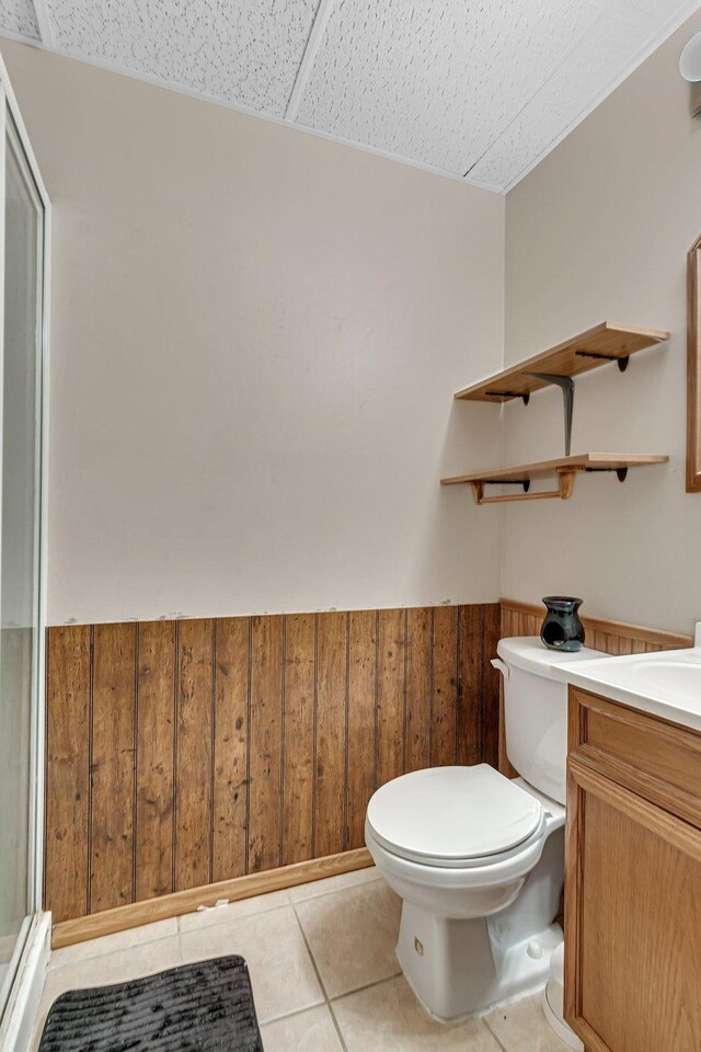 1410 12th Ave N, Saint Cloud, MN 56303 - bathroom with wainscoting, toilet, vanity, tile patterned flooring, and a shower stall