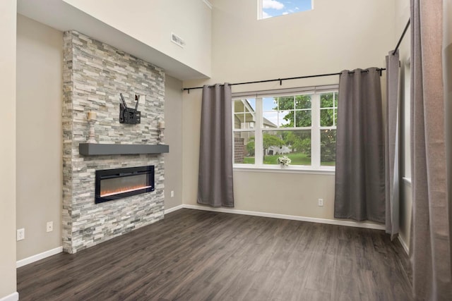20338 Kensfield Trl Unit 1606, Lakeville, MN 55044 - unfurnished living room featuring dark wood-style flooring, a stone fireplace, baseboards, and a high ceiling