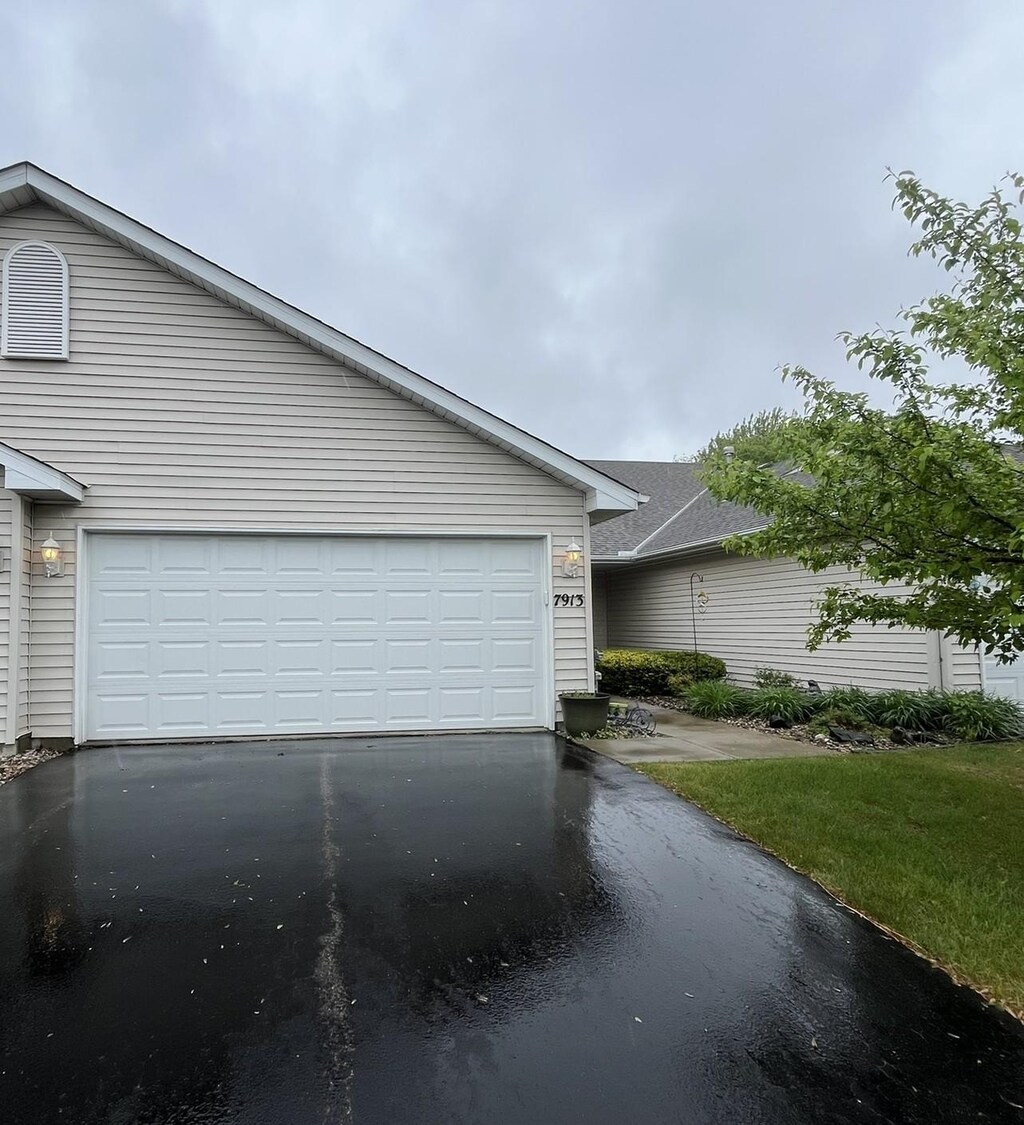 7913 Barrymore Ln, Woodbury, MN 55125 - view of front of property with driveway and an attached garage