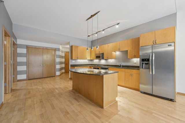 401 2nd St N Unit 220, Minneapolis, MN 55401 - kitchen featuring appliances with stainless steel finishes, light wood-type flooring, a sink, a center island, and pendant lighting