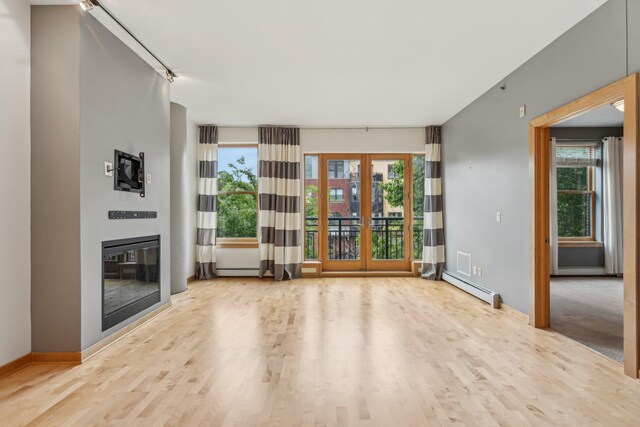 401 2nd St N Unit 220, Minneapolis, MN 55401 - unfurnished living room featuring french doors, plenty of natural light, wood finished floors, and baseboard heating
