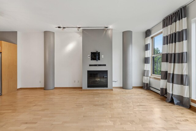 401 2nd St N Unit 220, Minneapolis, MN 55401 - unfurnished living room featuring light wood finished floors, a glass covered fireplace, baseboards, and a baseboard radiator