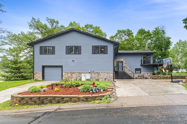 1680 Bluebird Ln, Mound, MN 55364 - split level home featuring concrete driveway, stone siding, and an attached garage