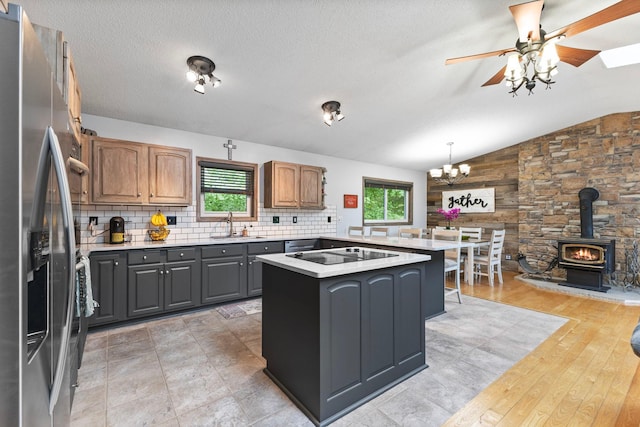1680 Bluebird Ln, Mound, MN 55364 - kitchen featuring stainless steel refrigerator with ice dispenser, black electric stovetop, a wood stove, light countertops, and a chandelier