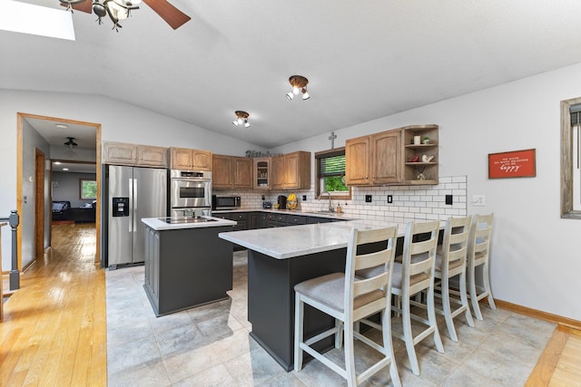 1680 Bluebird Ln, Mound, MN 55364 - kitchen with stainless steel appliances, a peninsula, vaulted ceiling, backsplash, and a sink