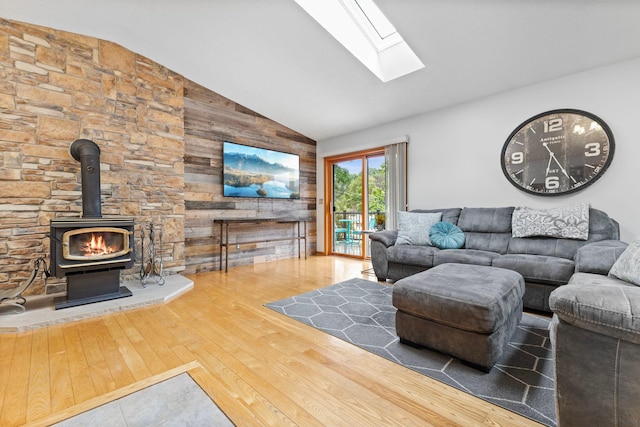1680 Bluebird Ln, Mound, MN 55364 - living room featuring a skylight, hardwood / wood-style flooring, a wood stove, wooden walls, and high vaulted ceiling
