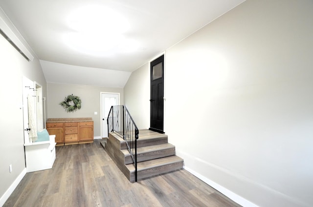415 Hubbard Ave N, Litchfield, MN 55355 - stairs featuring wood finished floors, baseboards, and lofted ceiling