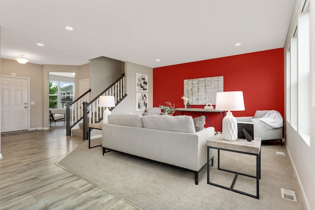 5010 Sandpebble Ln, Woodbury, MN 55129 - living area with an accent wall, wood finished floors, stairs, recessed lighting, and baseboards