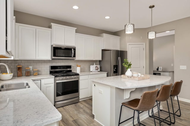5010 Sandpebble Ln, Woodbury, MN 55129 - kitchen with stainless steel appliances, a sink, light wood finished floors, a kitchen island, and recessed lighting