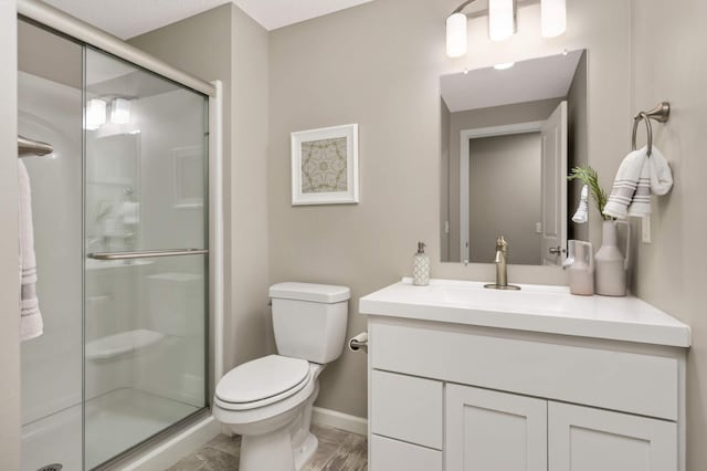 5010 Sandpebble Ln, Woodbury, MN 55129 - full bathroom featuring vanity, toilet, a shower stall, and baseboards
