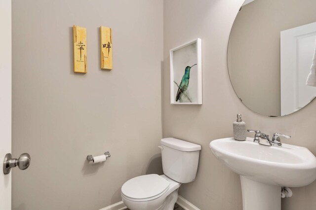 5010 Sandpebble Ln, Woodbury, MN 55129 - bathroom featuring toilet, baseboards, and a sink