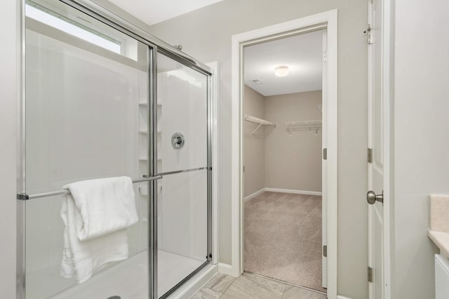 5010 Sandpebble Ln, Woodbury, MN 55129 - bathroom featuring a shower stall, a spacious closet, and baseboards